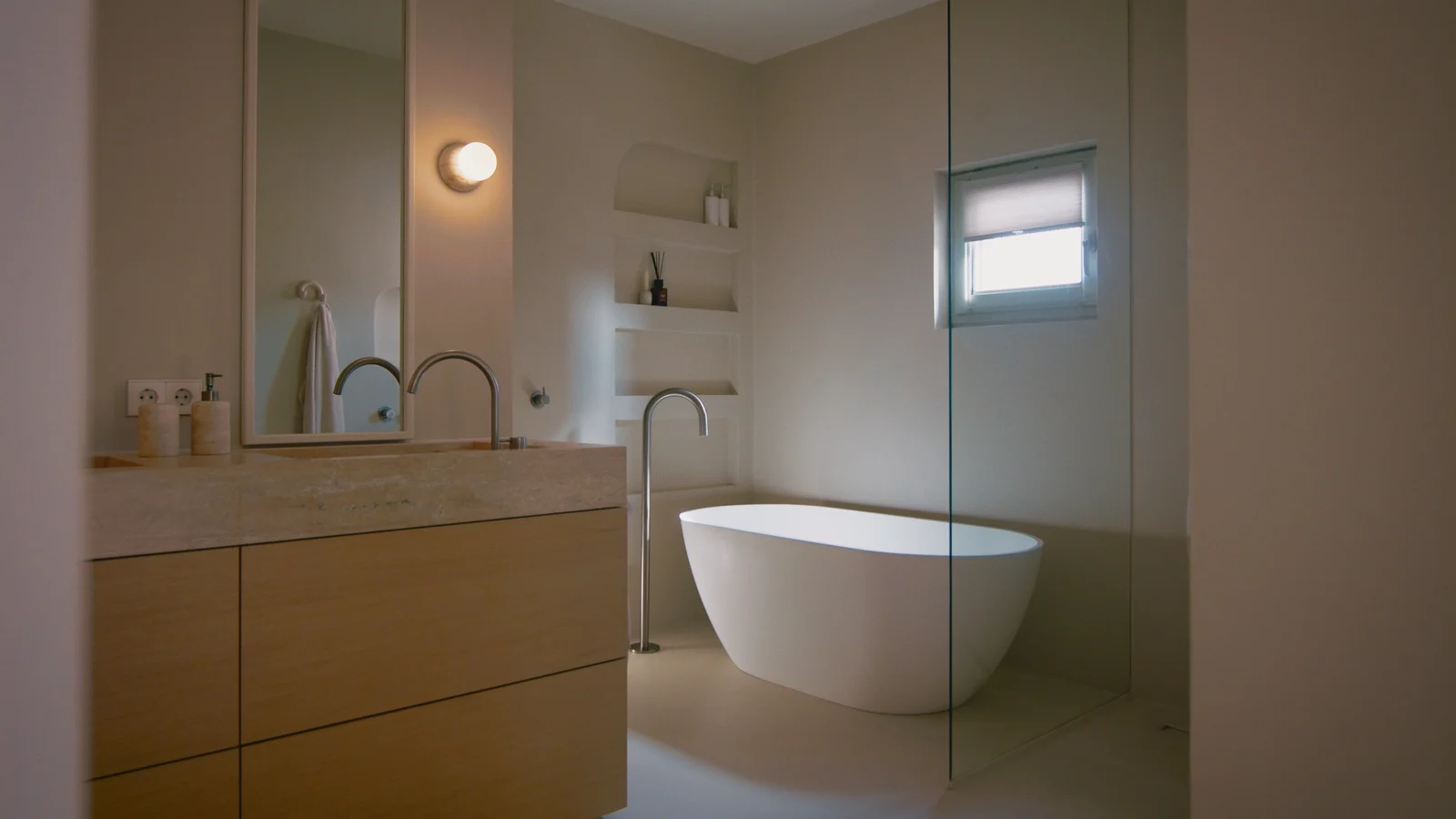 Badkamer met badmeubel en vrijstaand bad